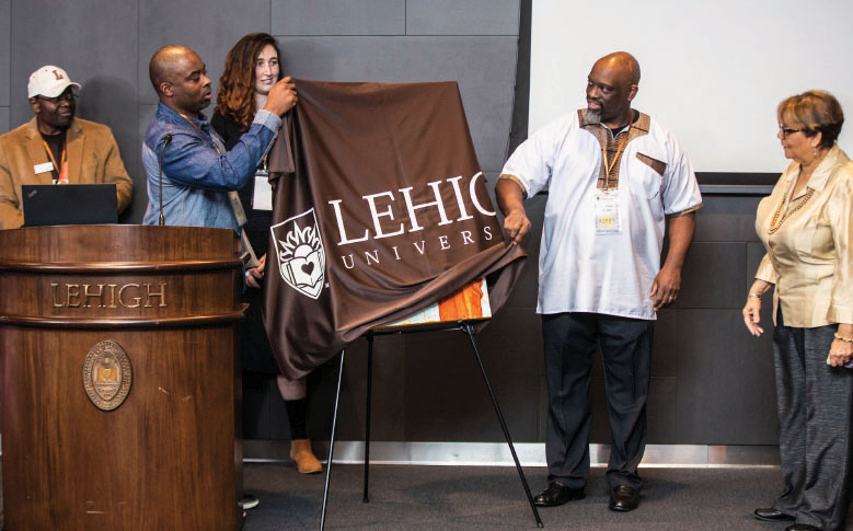 Banner with Lehigh University logo being lifted off portrait of Sterling Ashby