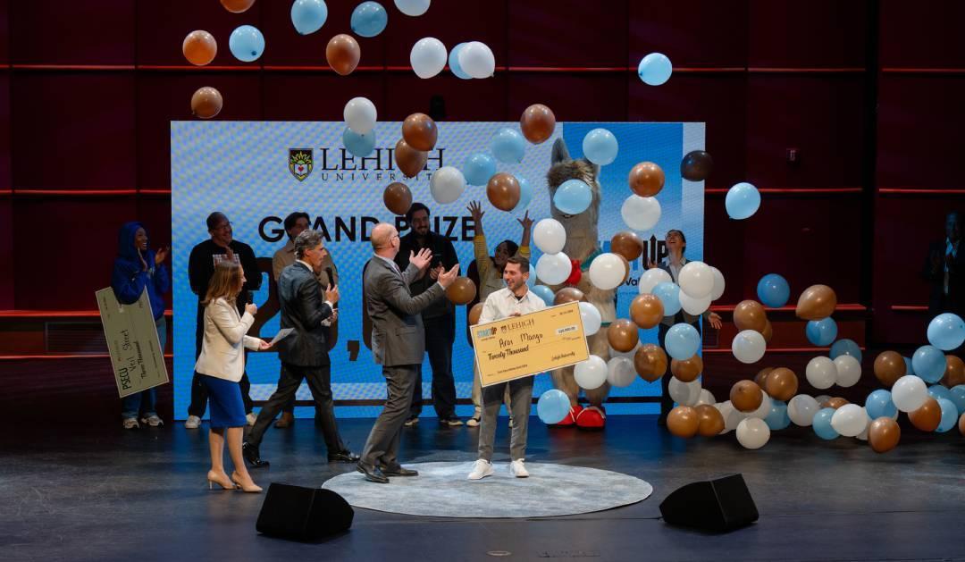 People on a stage wth balloons falling