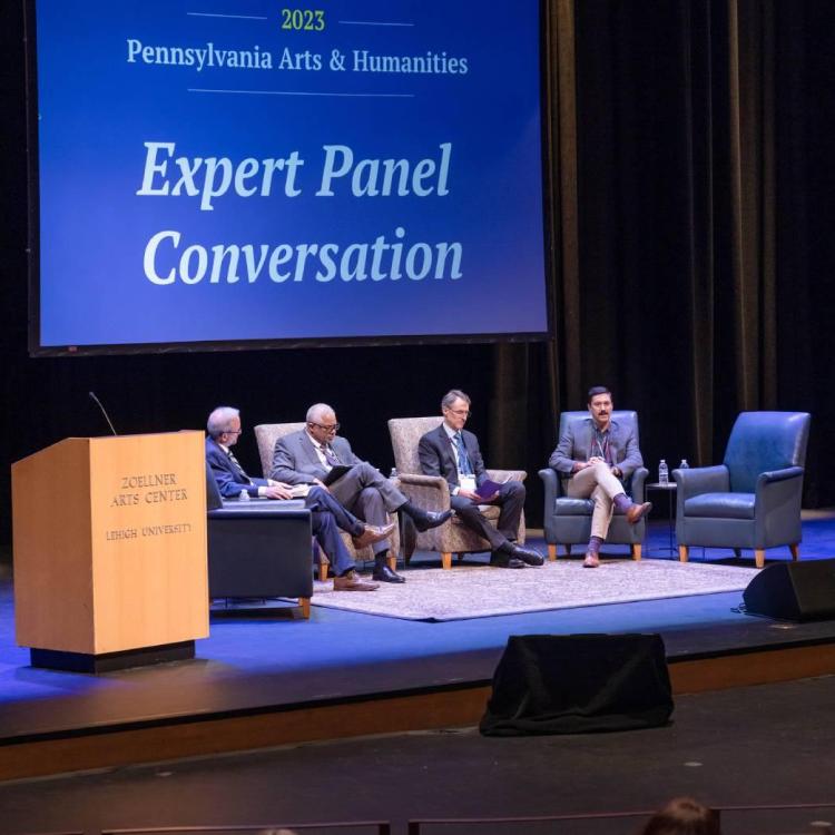 Three people sitting on a stage during a panel discussion