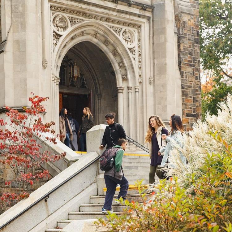 Exterior of a building with students walking down stairs