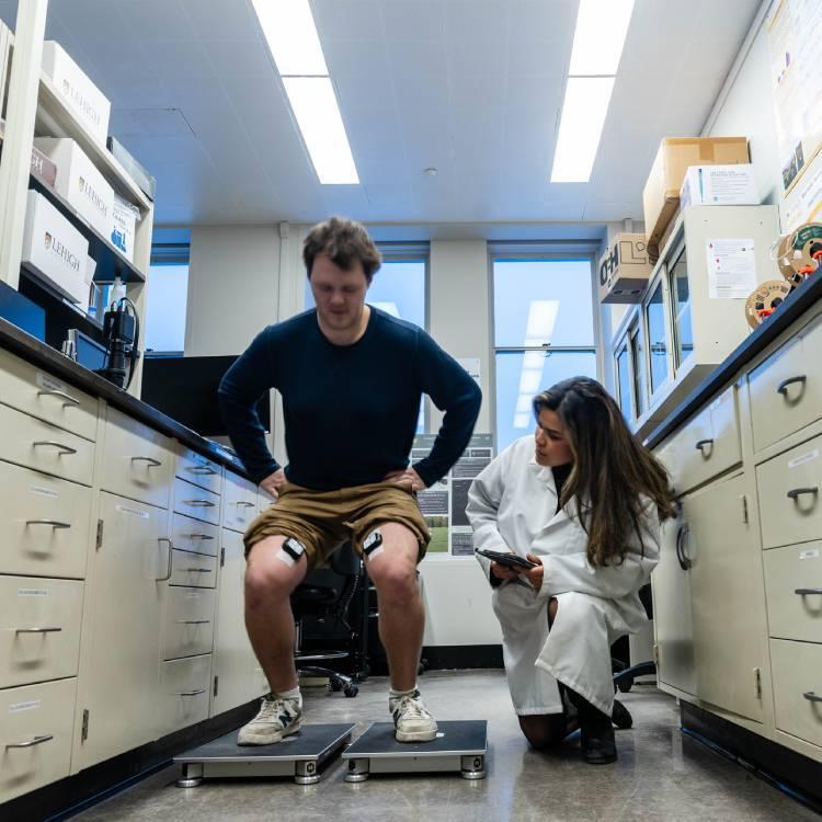 Person sitting on a scale with a technician looking on