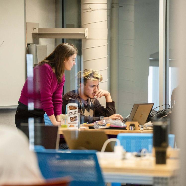 A student with a professor looking over their shoulder
