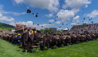 graduates toss their mortarboards