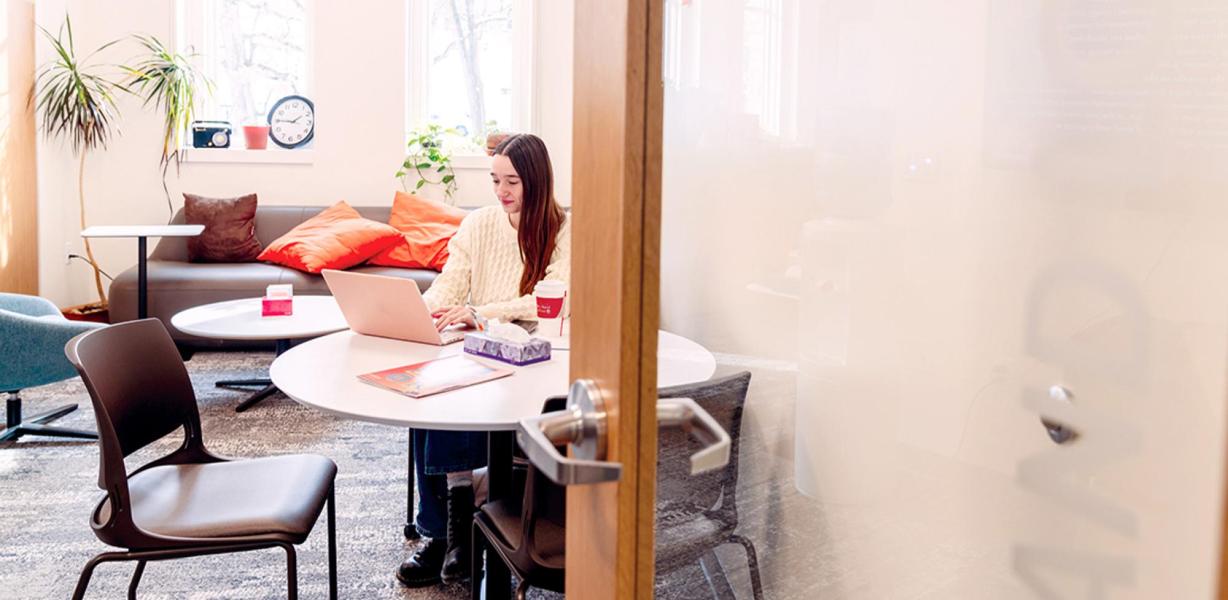 Student seated at a table with a laptop
