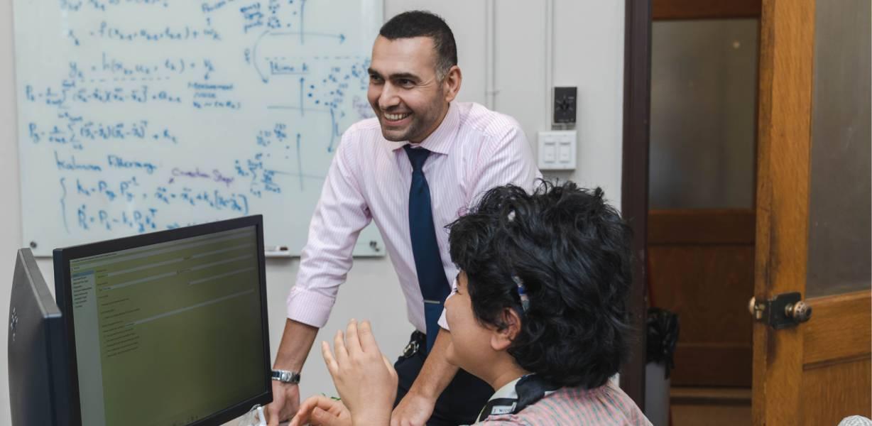 Two people working in an office. One is seated
