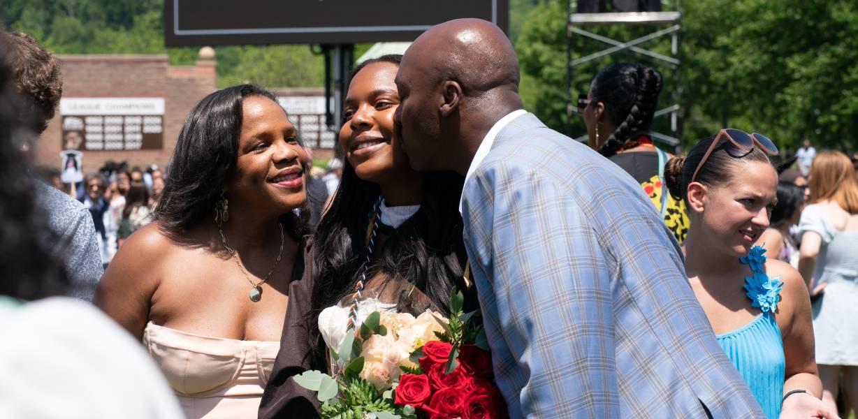 Two parents with their child at graduation