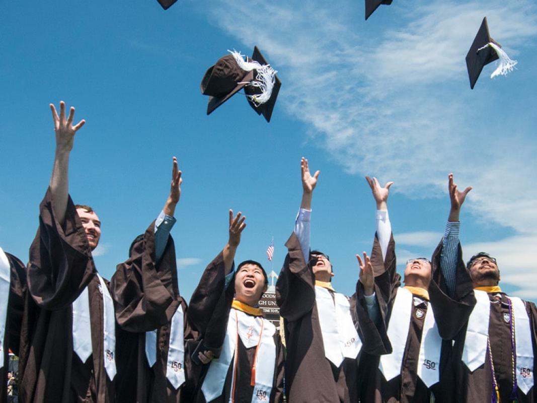 Graduates tossing their caps in the air at Commencement