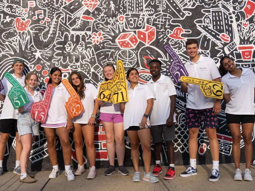 Students standing in front of a mural