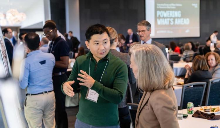 Attendees talking at the symposium
