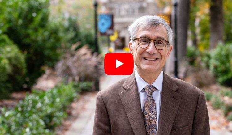 President Helble standing on campus on walking path
