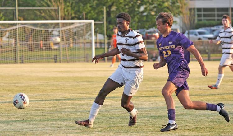 Soccer players in striped and purple jerseys compete for the ball on a field.